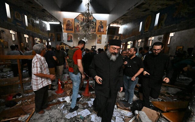 A priest reacts as people and rescuers inspect the damage at the site of a reported suicide attack at the Saint Elias church in Damascus' Dweila area on June 22, 2025. (LOUAI BESHARA / AFP)