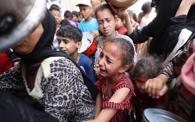 A Palestinian girl reacts as people queue at a food distribution point in Nuseirat, in the central Gaza Strip, on June 23, 2025. (Photo by Eyad BABA / AFP) A Palestinian girl reacts as people queue at a food distribution point in Nuseirat, in the central Gaza Strip, on June 23, 2025. (Photo by Eyad BABA / AFP)