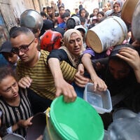 Palestinians queue at a food distribution point in Nuseirat, in the central Gaza Strip, on June 23, 2025. (Eyad BABA / AFP)