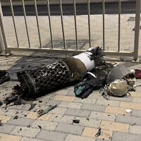 This frame grab take from AFPTV footage shows the remnants of an Iranian missile intercepted over Qatar, as it lies on a pavement near a fence on June 23, 2025. (Photo by AFPTV / AFP)