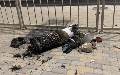 This frame grab take from AFPTV footage shows the remnants of an Iranian missile intercepted over Qatar, as it lies on a pavement near a fence on June 23, 2025. (Photo by AFPTV / AFP)