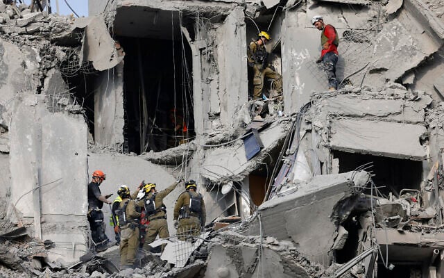 Israeli soldiers and rescue teams search for survivors amid the rubble of residential buildings destroyed by an Iranian missile strike that killed several people, in Beersheba, Israel, on June 24, 2025 (John Wessels / AFP)