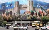 Vehicles drive past an anti-Israeli banner depicting Iranian soldiers heading to attack Israeli territory on Enghelab (Revolution) Square, in Tehran on June 24, 2025 (ATTA KENARE / AFP)