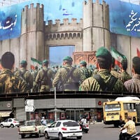 Vehicles drive past an anti-Israeli banner depicting Iranian soldiers heading to attack Israeli territory on Enghelab (Revolution) Square, in Tehran on June 24, 2025 (ATTA KENARE / AFP)