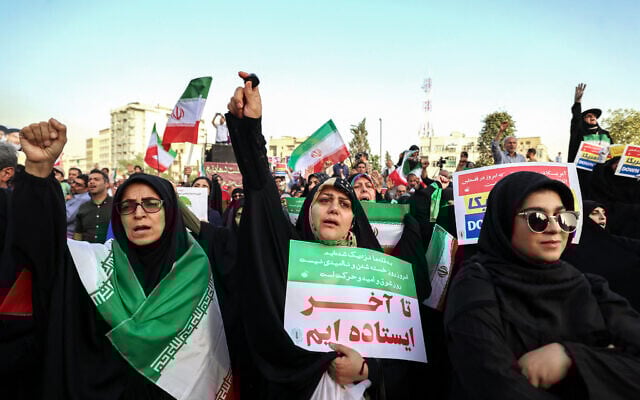 Iranians chant slogans and wave national flags as they celebrate a ceasefire between Iran and Israel at Enghlab Square in the capital Tehran on June 24, 2025. (Photo by ATTA KENARE / AFP)