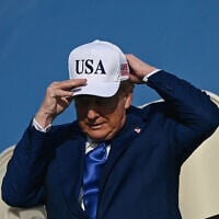 US President Donald Trump adjusts his cap as he exits Air Force One, which landed at Amsterdam's Schiphol airport, to attend the NATO summit in The Hague, on June 24, 2025. (Brendan Smialowski/AFP)