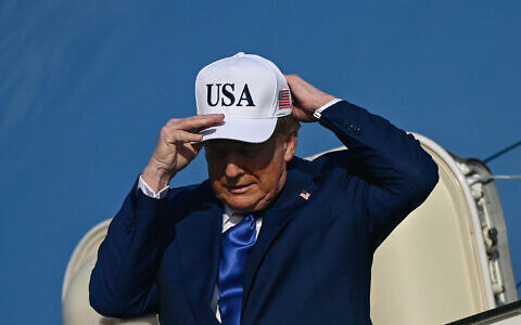 US President Donald Trump adjusts his cap as he exits Air Force One, which landed at Amsterdam's Schiphol airport, to attend the NATO summit in The Hague, on June 24, 2025. (Brendan Smialowski/AFP)