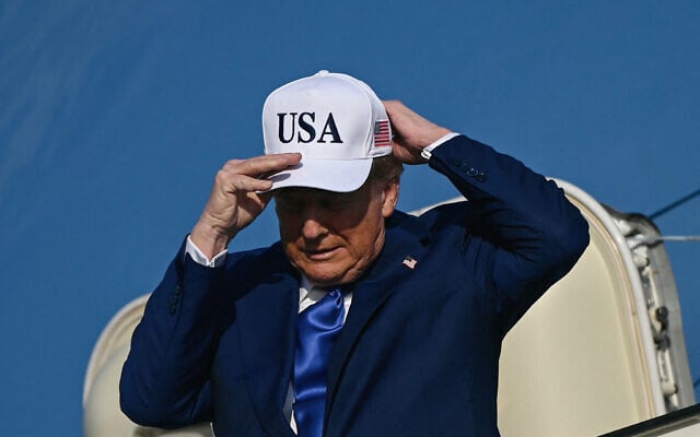US President Donald Trump adjusts his cap as he exits Air Force One, which landed at Amsterdam's Schiphol airport, to attend the NATO summit in The Hague, on June 24, 2025. (Brendan Smialowski/AFP)