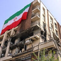 This picture shows a residential building that was hit in an Israeli strike covered with a big Iranian flag, in Tehran on June 25, 2025. (Atta Kenare/AFP)