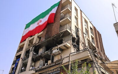 This picture shows a residential building that was hit in an Israeli strike covered with a big Iranian flag, in Tehran on June 25, 2025. (Atta Kenare/AFP)