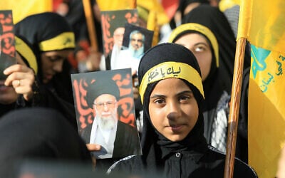 Supporters of Lebanon's Hezbollah wave flags and hold pictures of their slain leader Hassan Nasrallah and Iran's supreme leader Ayatollah Ali Khamenei, during a rally outside the Iranian Embassy in Beirut's southern suburbs, to celebrate a ceasefire between Israel and Iran, on June 25, 2025. (Haitham MOUSSAWI / AFP)