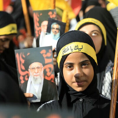 Supporters of Lebanon's Hezbollah wave flags and hold pictures of their slain leader Hassan Nasrallah and Iran's supreme leader Ayatollah Ali Khamenei, during a rally outside the Iranian Embassy in Beirut's southern suburbs, to celebrate a ceasefire between Israel and Iran, on June 25, 2025. (Haitham MOUSSAWI / AFP)
