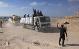 Gunmen are seen on trucks carrying aid after they entered the northern Gaza Strip from Israel, west of Beit Lahia on June 25, 2025. (Bashar Taleb/AFP)