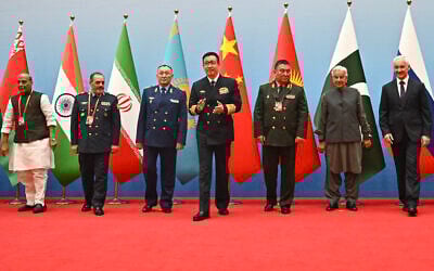 (L-R) India's Defense Minister Rajnath Singh, Iran's Defence Minister Aziz Nasirzadeh, Kazakhstan's Defense Minister Dauren Kossanov, China's Defense Minister Dong Jun, Kyrgyzstan's Defense Minister Ruslan Mukambetov, Pakistan's Defense Minister Khawaja Muhammad Asif, and Russia's Defense Minister Andrei Belousov gather for a group photo during the Defense Ministers' Meeting of the Shanghai Cooperation Organization (SCO) Member States in Qingdao, in eastern China's Shandong province on June 26, 2025. (Photo by Pedro PARDO / AFP)