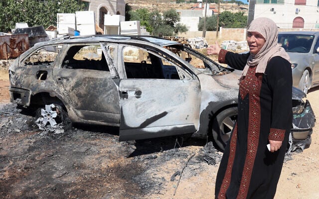 A Palestinian woman gestures in front of a burnt car after an Israeli settlers attack the previous day in Kafr Malik in the Israeli occupied West Bank, on June 26, 2025. (Zain JAAFAR / AFP) A Palestinian woman gestures in front of a burnt car after an Israeli settlers attack the previous day in Kafr Malik in the Israeli occupied West Bank, on June 26, 2025. (Zain JAAFAR / AFP)