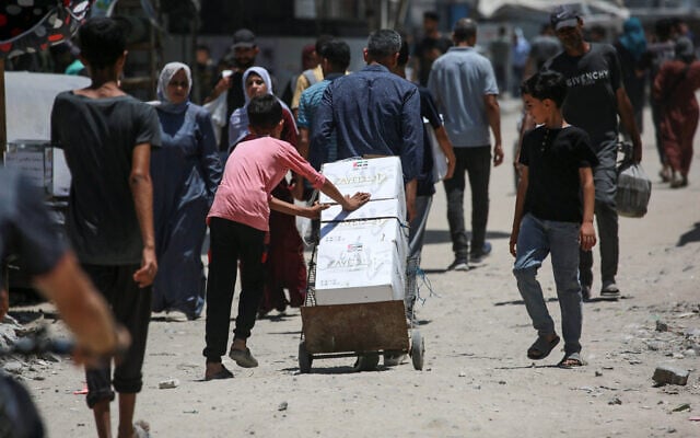 A Palestinian child transports food parcels donated by the United Arab Emirates, from a distribution point supervised by volunteers from Palestinian families organized in committees to prevent theft, in Gaza City on June 26, 2025. (Photo by Bashar TALEB / AFP) A Palestinian child transports food parcels donated by the United Arab Emirates, from a distribution point supervised by volunteers from Palestinian families organized in committees to prevent theft, in Gaza City on June 26, 2025. (Photo by Bashar TALEB / AFP)