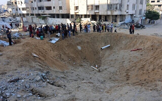 Palestinians gather around a huge crater after an Israeli strike hit the tents of displaced people in the northern Al-Rimal neighborhood of Gaza City on June 28, 2025. (Omar AL-QATTAA / AFP) Palestinians gather around a huge crater after an Israeli strike hit the tents of displaced people in the northern Al-Rimal neighborhood of Gaza City on June 28, 2025. (Omar AL-QATTAA / AFP)