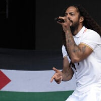 To the backdrop of a Palestinian flag, Bobby Vylan of British duo Bob Vylan performs on the West Holts Stage on the fourth day of the Glastonbury festival at Worthy Farm in the village of Pilton in Somerset, southwest England, on June 28, 2025. (Oli SCARFF / AFP)