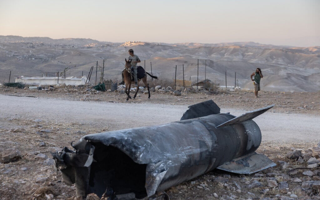 A man rides a horse next to the remains of an Iranian missile that fell at an outpost near the Israeli settlement of Tekoa in the West Bank, on June 29, 2025.  (Menahem Kahana / AFP)