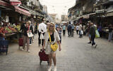 Illustrative: A woman shops at the Machane Yehuda Market in Jerusalem, April 8, 2025. (AP Photo/Maya Alleruzzo)