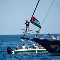 Activist Greta Thunberg stands near a Palestinian flag after boarding the Madleen boat and before setting sail for Gaza along with activists of the Freedom Flotilla Coalition, departing from the Sicilian port of Catania, Italy on June 1, 2025. (AP Photo/Salvatore Cavalli)