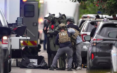 Law enforcement officials dress in protective gear to investigate after an attack on hostage demonstrators at the Pearl Street Mall in Boulder, Colorado, June 1, 2025. (AP Photo/David Zalubowski)