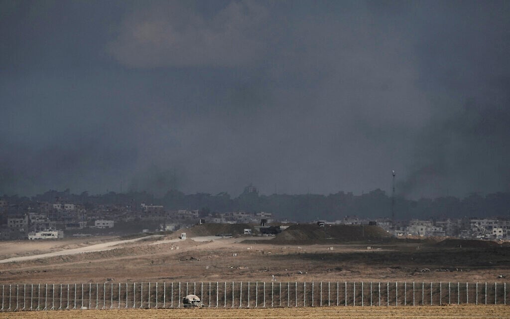 An Israeli military vehicle drives along the Israel-Gaza border as smoke from Israeli strikes envelops buildings in the northern Gaza Strip, seen from southern Israel, June 2, 2025. (AP Photo/Maya Alleruzzo)