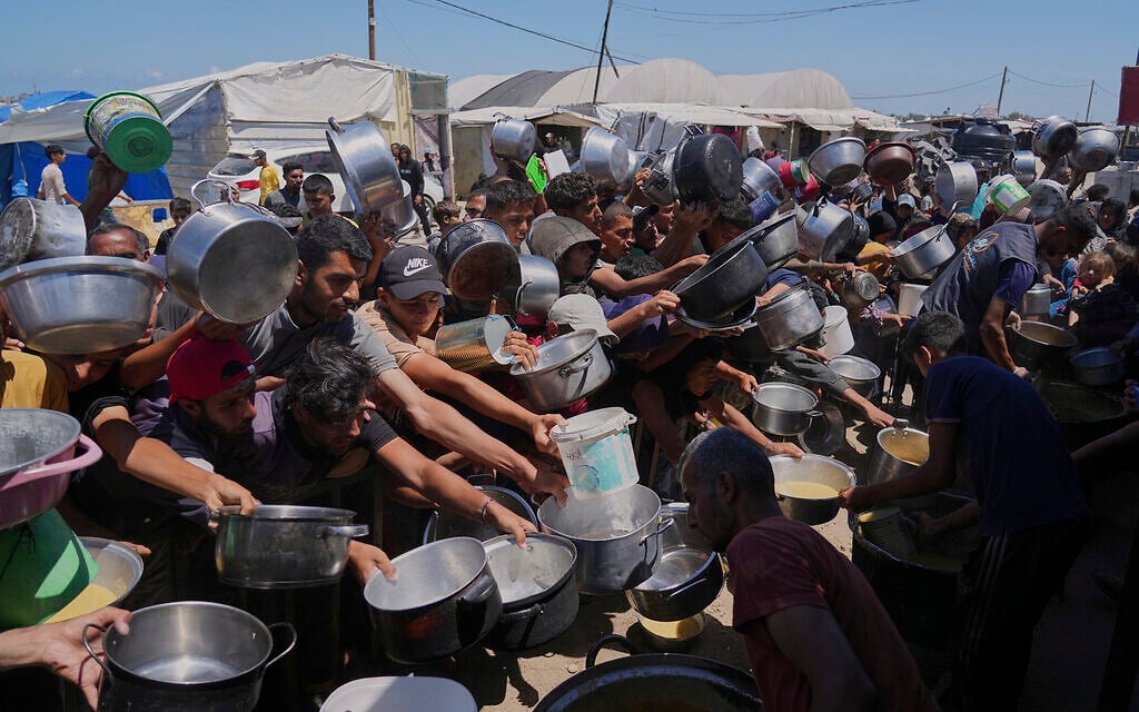 Palestinians struggle to get donated food at a community kitchen in Khan Younis, southern Gaza Strip, June 2, 2025. (AP Photo/Abdel Kareem Hana)
