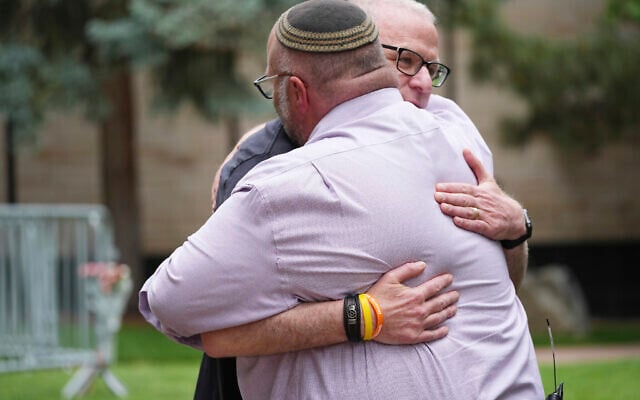 Rabbi Fred Greene of Congregation Har Hashem, front, hugs a man outside of the Boulder County, Colorado, courthouse after an attack on hostage protesters, June 2, 2025, in Boulder, Colorado. (AP Photo/David Zalubowski)