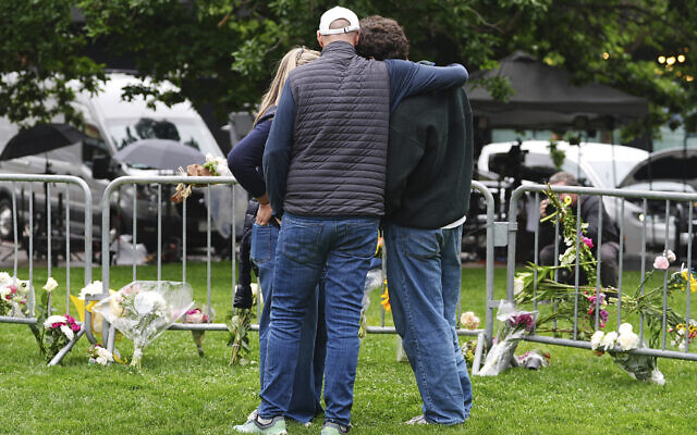 As Jennifer Dechtman, back, looks on, her husband Evan, front left, consoles his son, Isaac, right, at a makeshift memorial for victims of an attack outside of the Boulder County, Colorado, courthouse, June 3, 2025, in Boulder, Colorado. (AP/David Zalubowski) As Jennifer Dechtman, back, looks on, her husband Evan, front left, consoles his son, Isaac, right, at a makeshift memorial for victims of an attack outside of the Boulder County, Colorado, courthouse, June 3, 2025, in Boulder, Colorado. (AP/David Zalubowski)