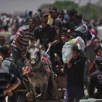 Palestinians carry bags containing food and humanitarian aid packages delivered by the Gaza Humanitarian Foundation, in Rafah, southern Gaza Strip, June 9, 2025. (AP Photo/Abdel Kareem Hana)