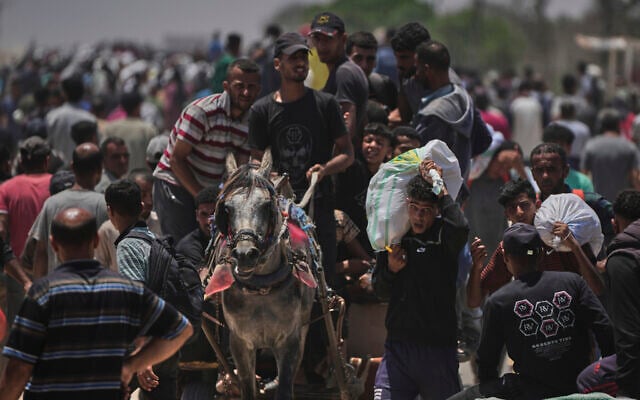 Palestinians carry bags containing food and humanitarian aid packages delivered by the Gaza Humanitarian Foundation, in Rafah, southern Gaza Strip, June 9, 2025. (AP Photo/Abdel Kareem Hana)