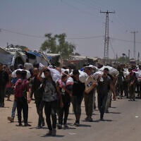 Palestinians carry bags containing food and humanitarian aid packages delivered by the Gaza Humanitarian Foundation, in Rafah, southern Gaza, June 9, 2025. (AP/Abdel Kareem Hana)