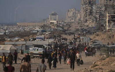 Displaced Palestinians walk past the ruins of destroyed buildings along the Gaza City shoreline, June 9, 2025. (AP Photo/Jehad Alshrafi)