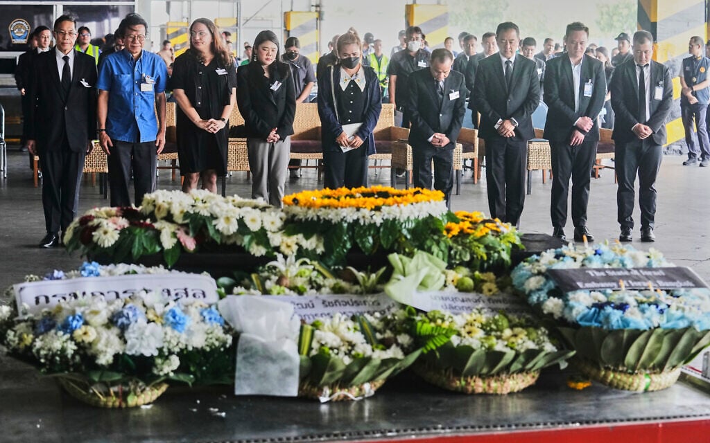 Narissara Chantasang, fifth from left, wife of Nattapong Pinta, a Thai laborer who was taken hostage and killed by terrorists in Gaza, attends a silent memorial service near the coffin containing his body at Suvarnabhumi International Airport in Samut Prakarn province Thailand, June 11, 2025. (AP Photo/Sakchai Lalit)