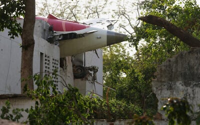 The tail of the airplane is seen stuck in a building at the site of an airplane that crashed in India's northwestern city of Ahmedabad in Gujarat state, June 12, 2025. (AP/Ajit Solanki)