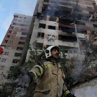 A firefighter calls out to his colleagues at the scene of an explosion in a residential compound in northern Tehran, Iran, June 13, 2025. (Vahid Salemi/AP)