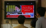 Pakistanis watch a news channel telecasting report about the Israeli attacks on Iran, in Peshawar, Pakistan, on June 13, 2025. (AP/Muhammad Sajjad)