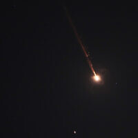 A projectile breaks up in the night sky over Jerusalem during an Iranian missile attack, early June 14, 2025. (AP Photo/Ohad Zwigenberg)