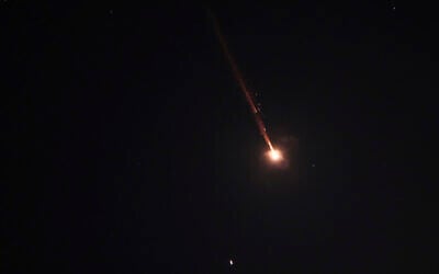 A projectile breaks up in the night sky over Jerusalem during an Iranian missile attack, early June 14, 2025. (AP Photo/Ohad Zwigenberg)