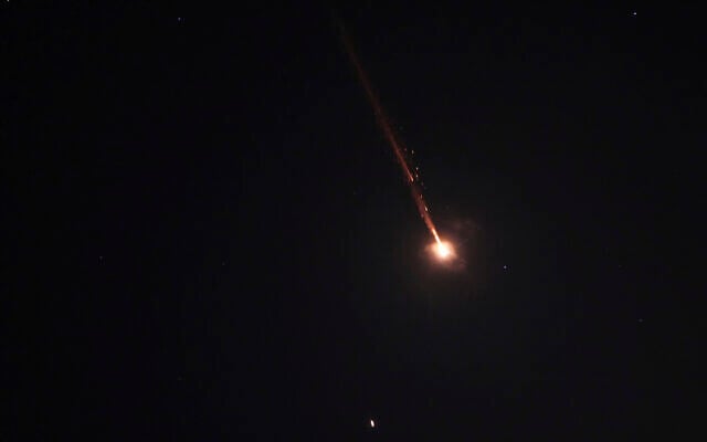 A projectile breaks up in the night sky over Jerusalem during an Iranian missile attack, early June 14, 2025. (AP Photo/Ohad Zwigenberg)
