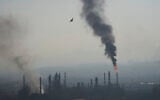 Smoke billows after an Iranian missile struck an oil refinery in Haifa, northern Israel, early Monday, June 16, 2025. (AP Photo/Ariel Schalit)
