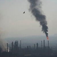 Smoke billows after an Iranian missile struck an oil refinery in Haifa, northern Israel, early June 16, 2025. (AP/Ariel Schalit)