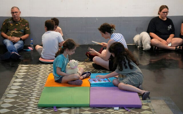 Israelis take shelter in a parking garage during a missile alert from Iran, in Tel Aviv, early June 17, 2025. (AP /Baz Ratner)
