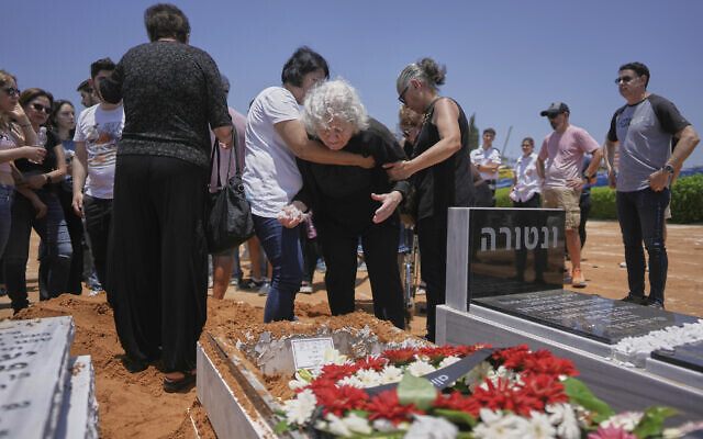 Relatives and friends of Daisy Yitzhaki, 85, who was killed during an Iranian missile attack, mourn during her funeral at Segula cemetery in Petah Tikva, June 18, 2025. (AP Photo/Oded Balilty)