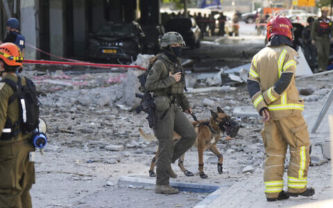 Israeli security forces and firefighters work at the site after a missile launched from Iran struck in Haifa, Israel, June 20, 2025. (AP Photo/Baz Ratner)