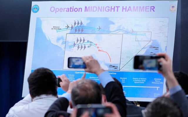 Reporters take photos of a displayed graphic as Defense Secretary Pete Hegseth and Joint Chiefs Chairman Gen. Dan Caine speak during a news conference at the Pentagon in Washington, June 22, 2025, after the U.S. military struck three sites in Iran, directly joining Israel's effort to destroy the country's nuclear program. (AP/Alex Brandon)