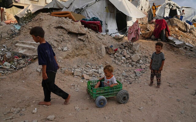 Displaced Palestinian play in a tent camp in Gaza City, Monday, June 23, 2025. (AP Photo/Jehad Alshrafi)