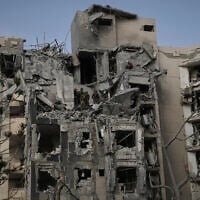 Israeli soldiers and rescue teams search for survivors amid the rubble of residential buildings destroyed by an Iranian missile strike that killed several people, in Beersheba, Israel, on June 24, 2025. (AP Photo/Leo Correa)