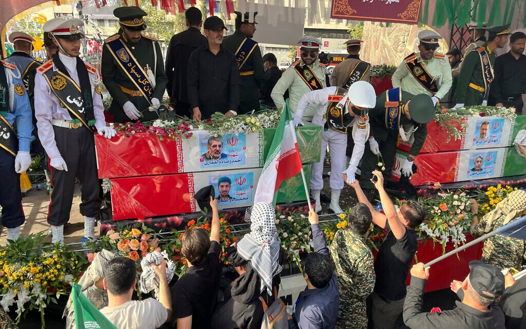 People mourn over the flag-draped coffins of Iranian nuclear scientists who were killed in Israeli strikes, during a funeral ceremony in Tehran, Iran, June 28, 2025. (AP Photo/Vahid Salemi)